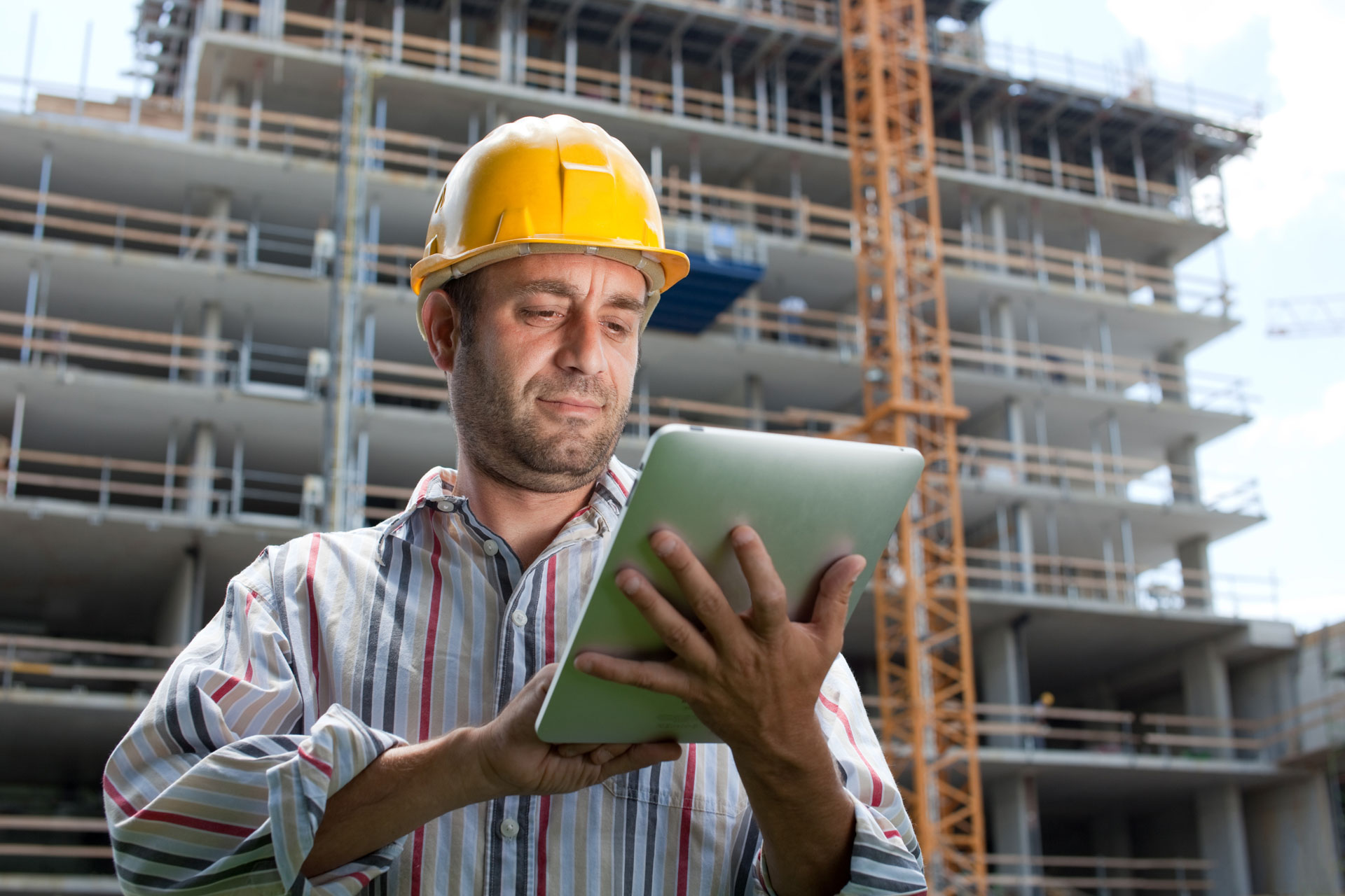 man in hardhat looking at ipad on construction site researching brisbane term loans