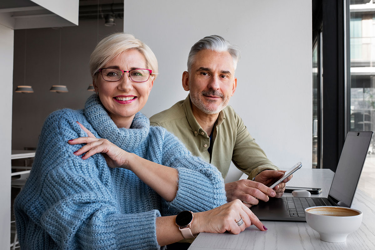 middle aged couple using phone laptop technology for their brisbane home loan