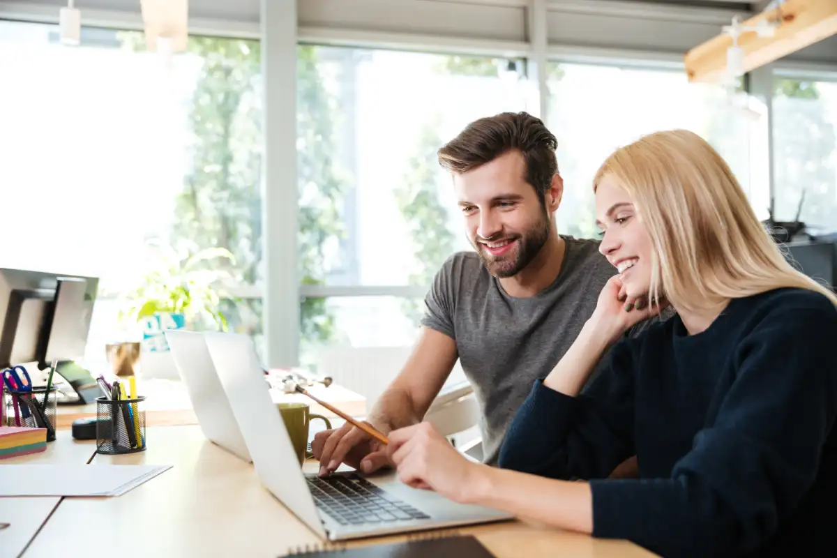 young happy couple using laptop reviewing tips to pay off your mortgage faster