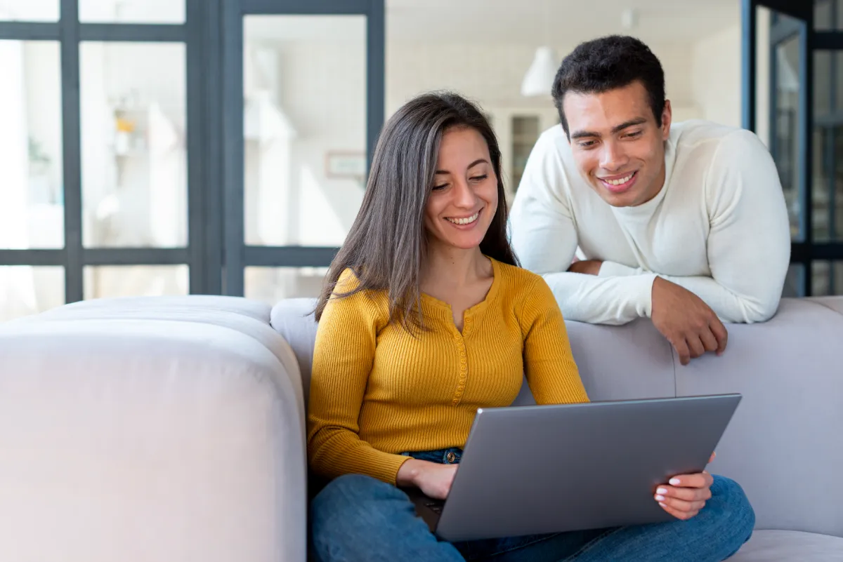young couple looking at laptop researching loan pre-approval checklists